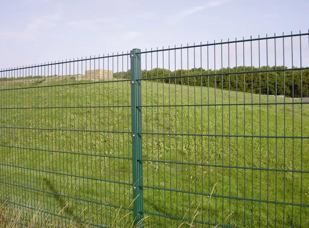 Double wire fence with dark steel posts beside a landscaped property