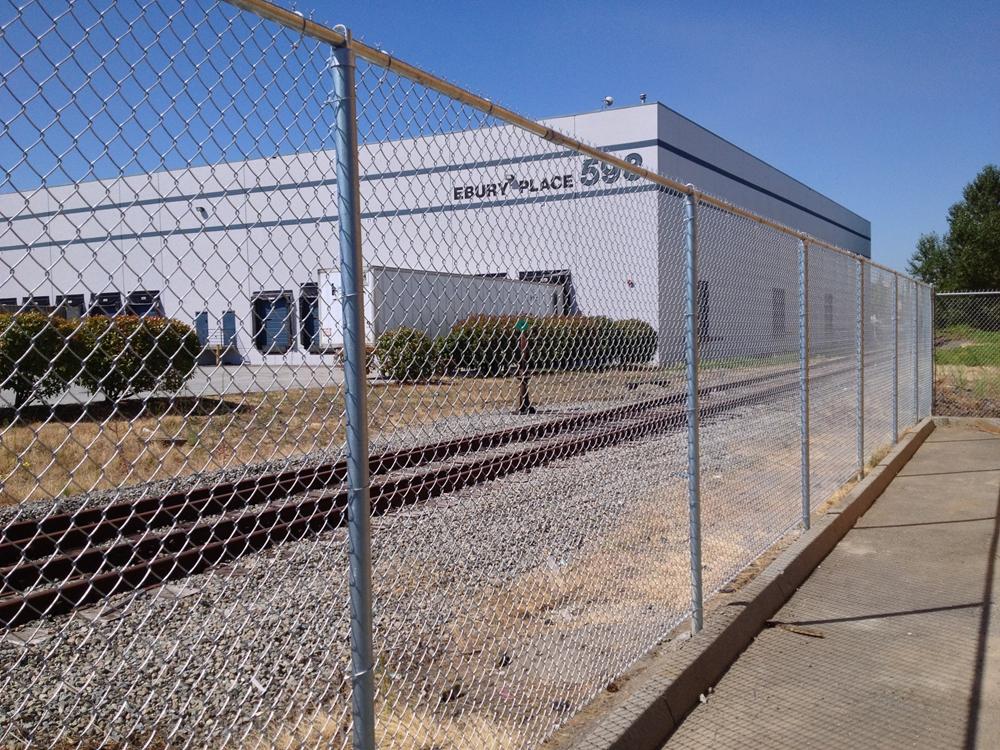 Person standing in a factory with machinery in the background