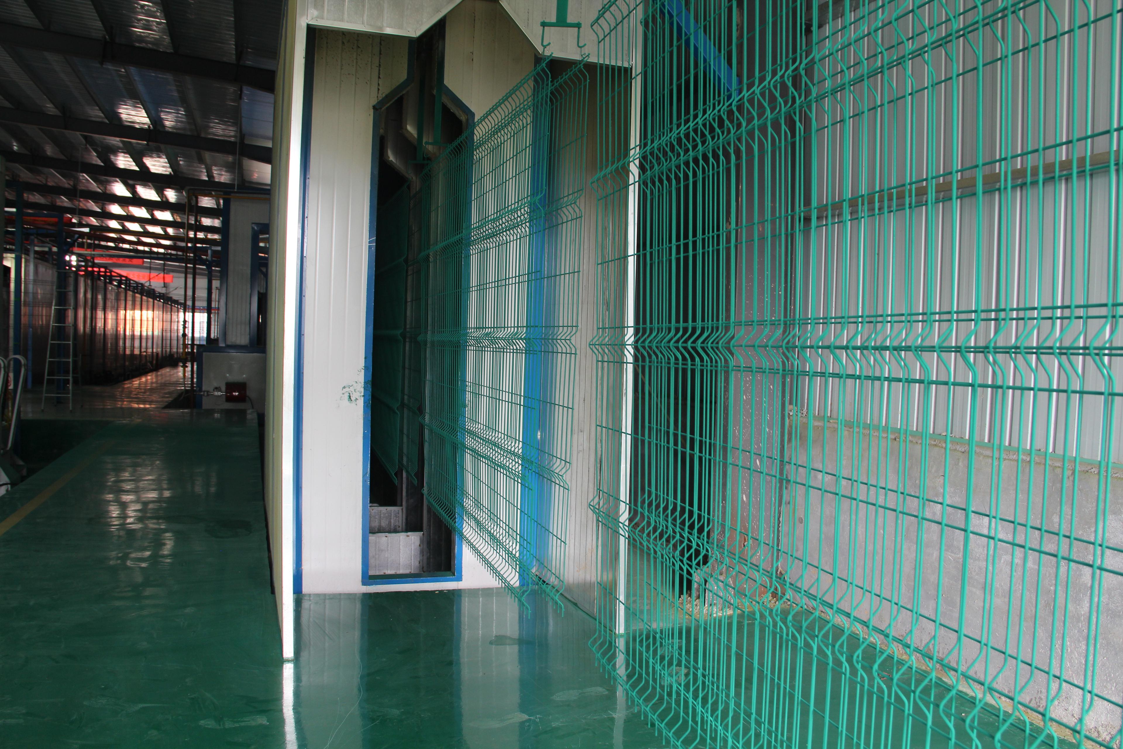 Person standing in a factory with machinery in the background