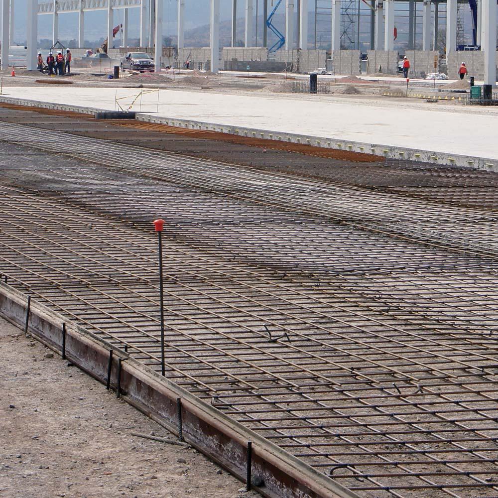 Person standing in a factory with machinery in the background
